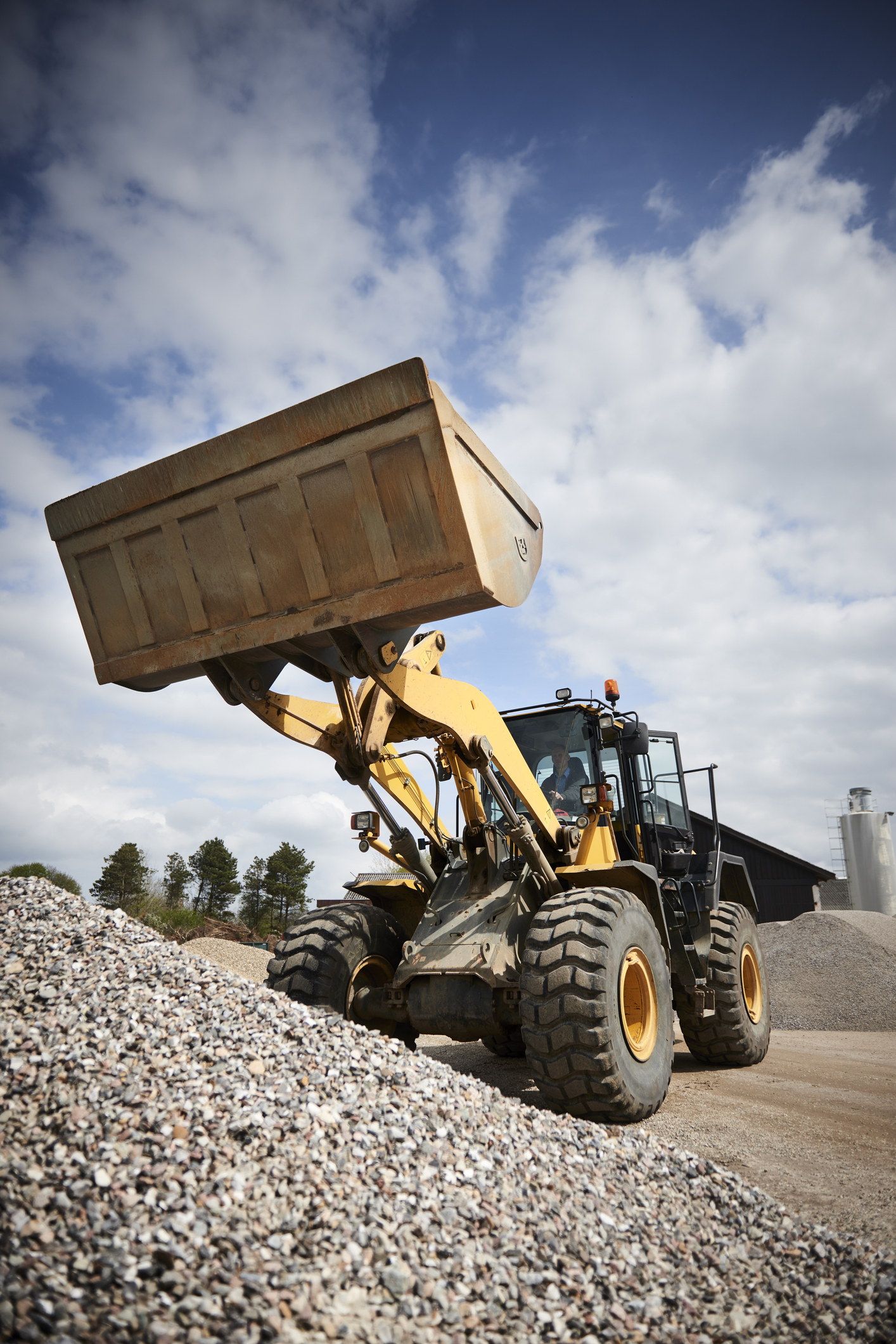 Excavator moving sand in a gravel pit Excavator and other heavy machinery warranty & insurance