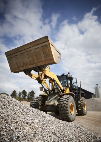 Excavator moving sand in a gravel pit Excavator and other heavy machinery warranty & insurance